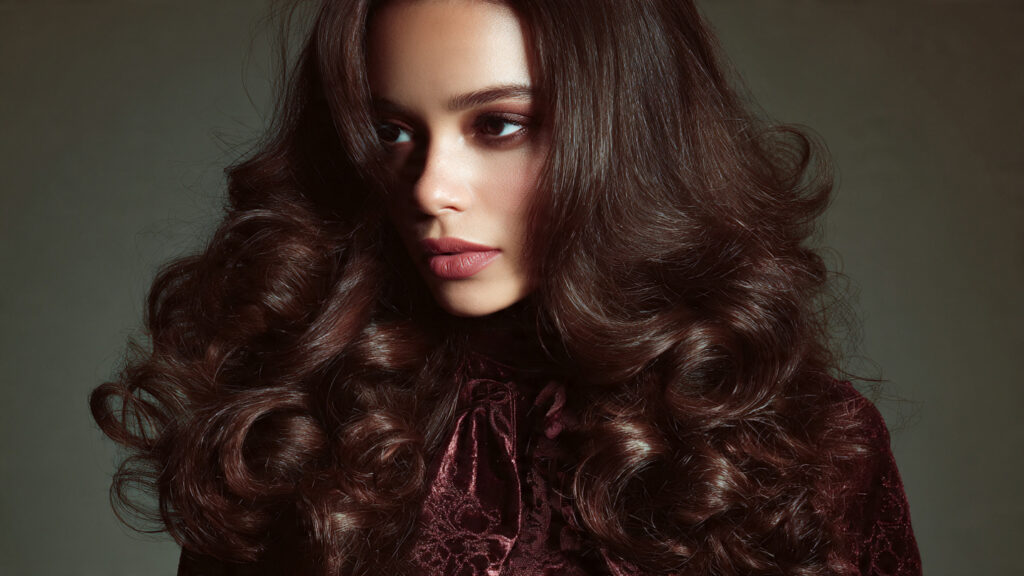Dark mocha brunette hair with voluminous curls and side part.