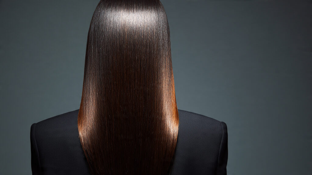 Long glossy espresso brunette hair styled straight with center part.