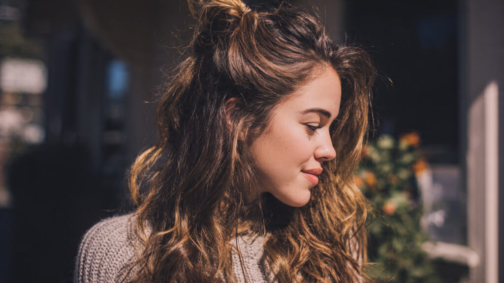 Honey brunette half-up hairstyle with soft waves.