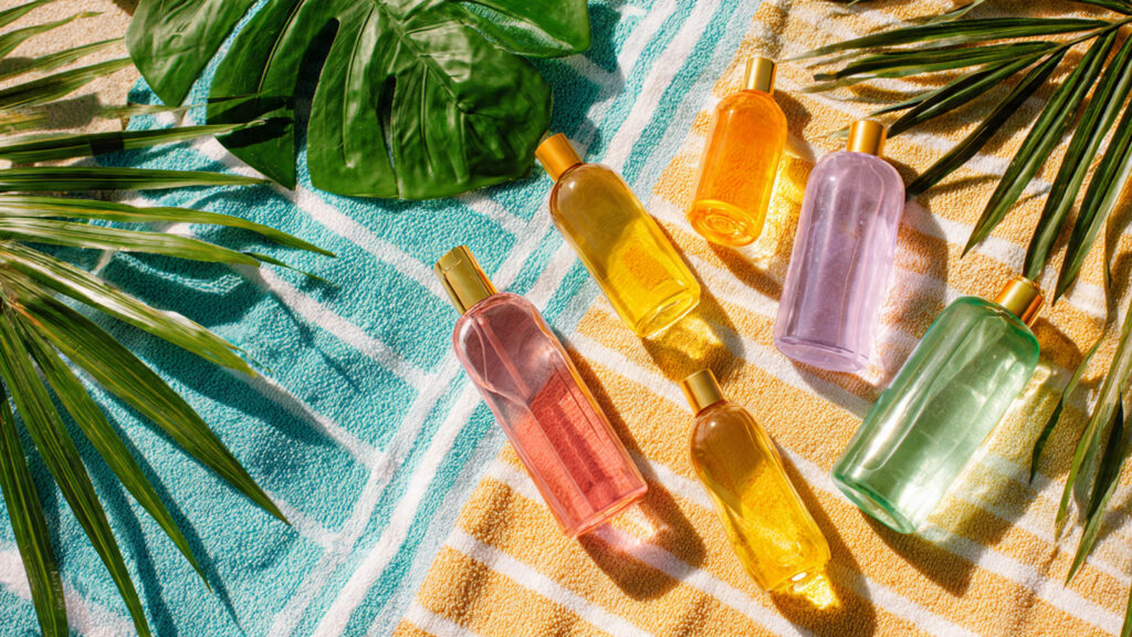 Different tanning oils and lotions displayed on a beach towel for summer skincare.