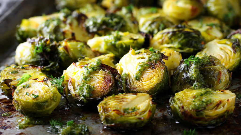 Roasted Brussels sprouts with pesto on a baking sheet